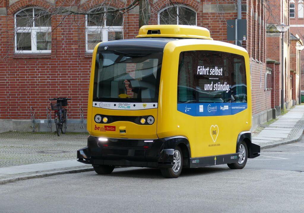 a yellow self-driving vehicle on a road.